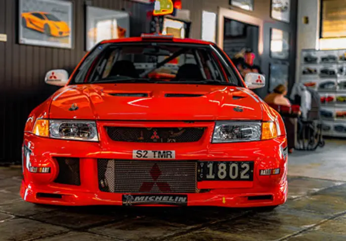 A red car parked in front of a building.