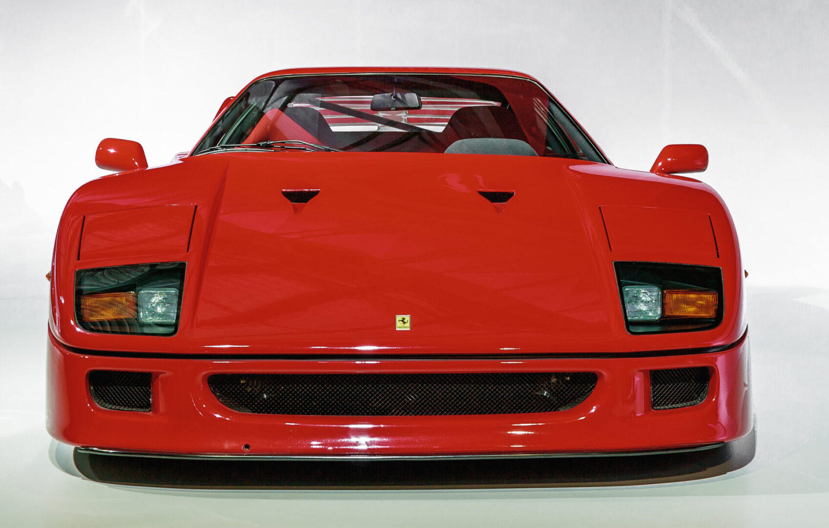 A red ferrari is shown with the hood up.